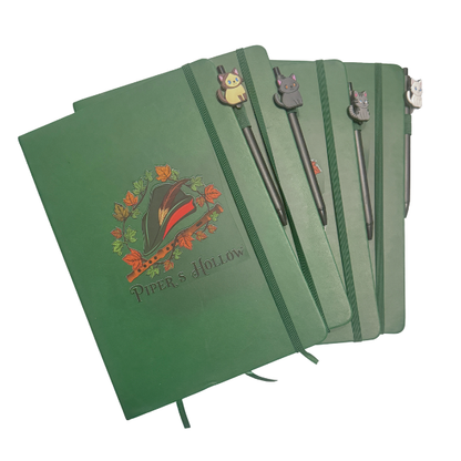 green lined journal with elastic band and cat pen set on white background