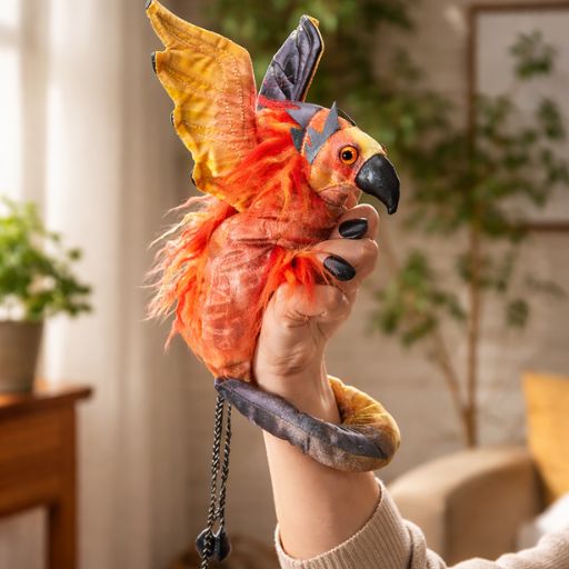 phoenix hand puppet wristlet with red and gold feathers worn on hand against white background