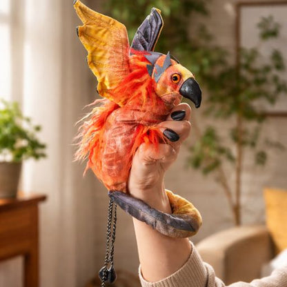phoenix hand puppet wristlet with red and gold feathers worn on hand against white background
